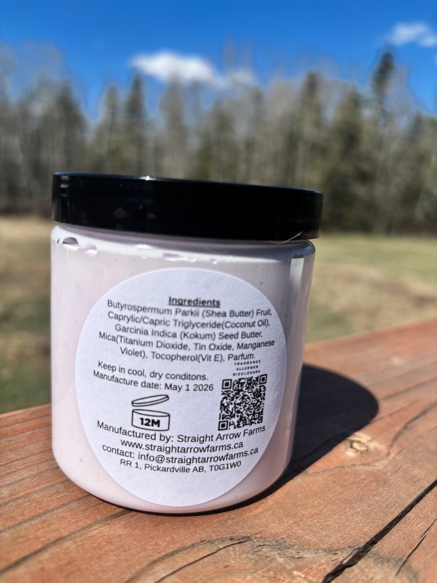 Jar with a black lid on a wooden surface outdoors
