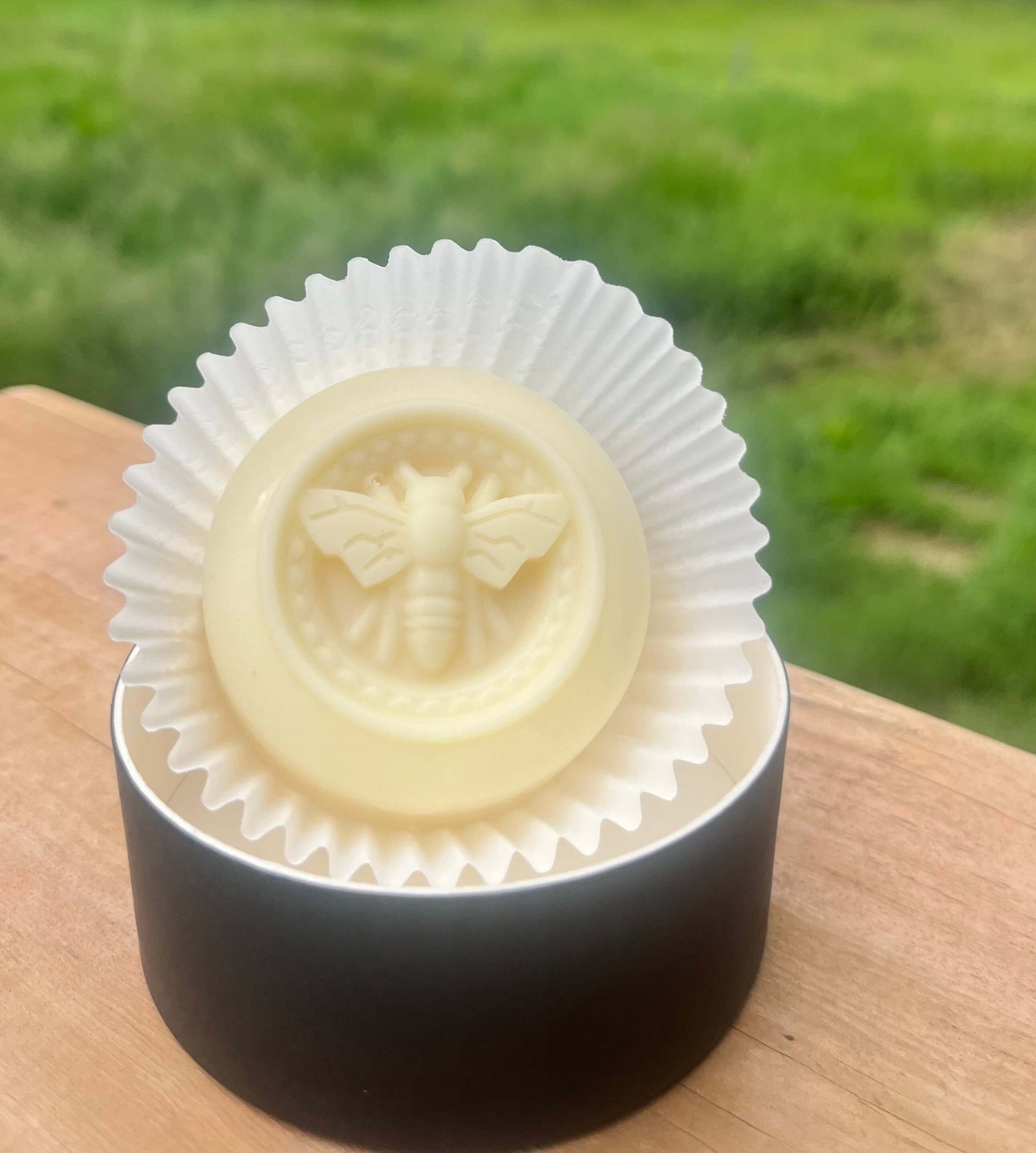 Luxurious solid lotion bar in an aluminum tin with a bee design, perfect for hydration and eco-friendly skincare.