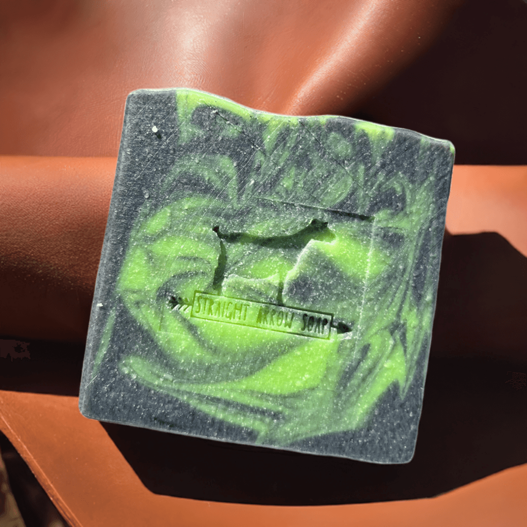 Big Boy Bar goat milk soap with smokey leather scent and activated charcoal on a rustic background.