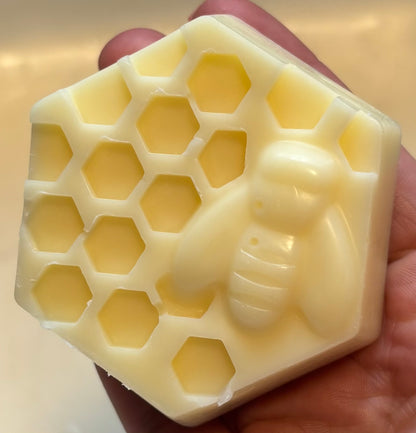 Hair conditioner bar with honeycomb and bee design held in hand