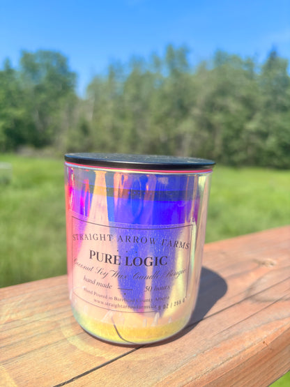 Iridescent candle labeled 'Pure Logic' on a wooden surface with a natural background