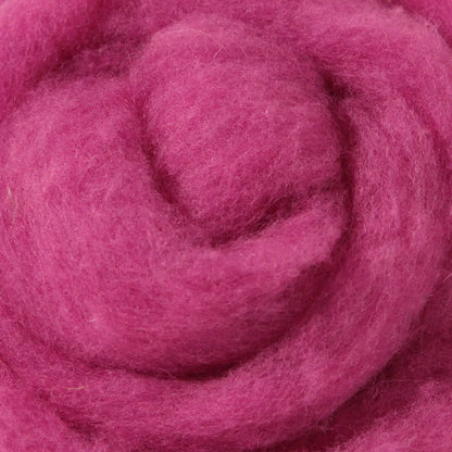 A basket containing multicolored wool dryer balls displayed outdoors with a scenic background.