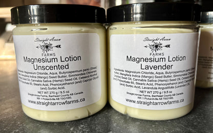 Two jars of magnesium lotion, one unscented and one lavender, from Straight Arrow Farms on a gray surface.