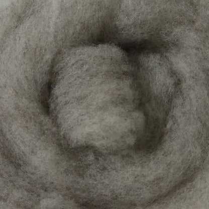 A basket containing multicolored wool dryer balls displayed outdoors with a scenic background.