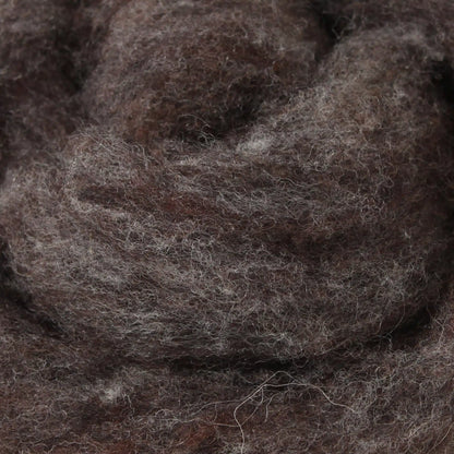 A basket containing multicolored wool dryer balls displayed outdoors with a scenic background.